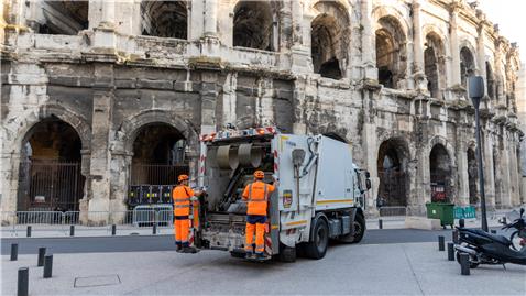 Ripeurs collectant des déchets ménagers devant les arènes, Nîmes, en juillet 2019